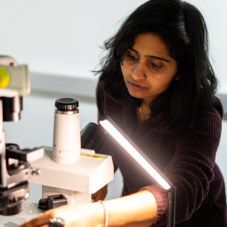 woman scientist works with microscope